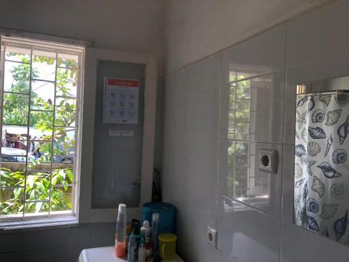un bagno con doccia, lavandino e finestra di Casa de Ferias a São Tomé