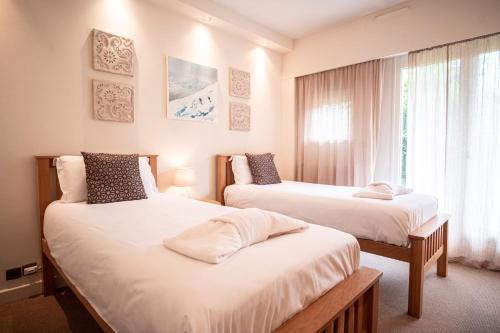 une chambre avec deux lits et une fenêtre dans l'établissement Les Aiguilles du Brevent - Grand Appt Renove - Central - Terrasse avec Vue, à Chamonix-Mont-Blanc