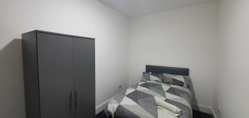 a bedroom with a bed and a black cabinet at Coventry Princess House in Coventry