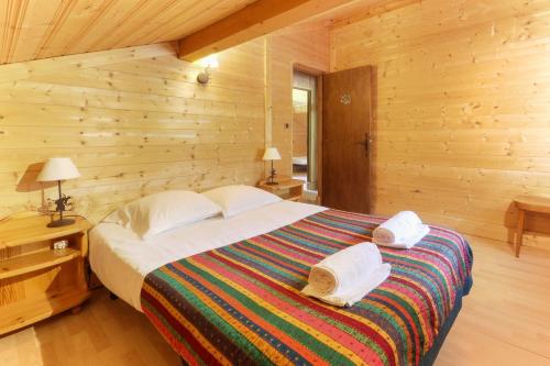 里雾诗Chalet YOLO, Vallée de Chamonix - sauna et jaccuzi的一间木屋里有一张大床的卧室