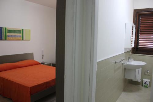 sypialnia z łóżkiem i umywalką w obiekcie Case Vacanze Flamingo w mieście Birgi Vecchi