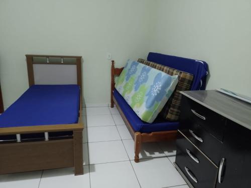 ein Schlafzimmer mit einem blauen Stuhl und einem Schreibtisch in der Unterkunft CHÁCARA KAUANNY SOCORRO SP in Socorro