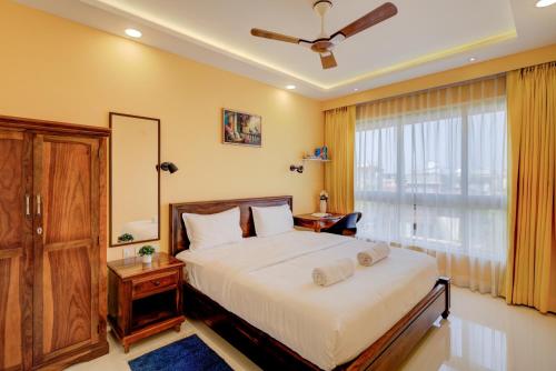 a bedroom with a large bed and a window at Premium 2BHK -10 min to GOI airport & beach -Pool access -Balcony with city view in Dabolim