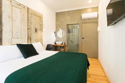 a bedroom with a large bed with a green blanket at 262 Boutique Hotel in Lisbon