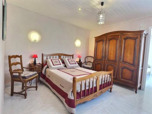 - une chambre avec un grand lit et une armoire en bois dans l'établissement Cape, à Sauvian