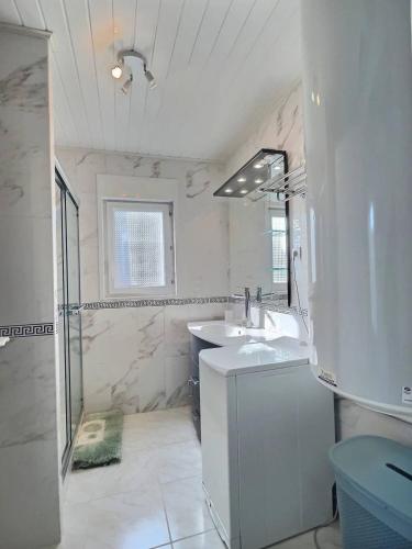 une salle de bain blanche avec un lavabo et une douche dans l'établissement Cape, à Sauvian