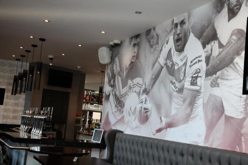 a large wall mural in a bar with players on it at The Eccleston Hotel; BW Signature Collection in Saint Helens