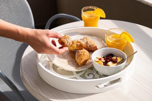 a person eating a plate of breakfast food on a table at Olympic Star Beach Hotel in Nei Poroi
