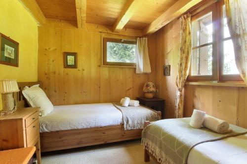 um quarto com 2 camas num chalé de madeira em Chalet de charme - 8 pers - 140m2 - Jardin - Calme em Les Houches