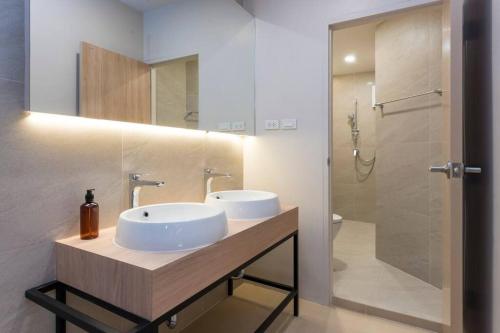 a bathroom with two sinks and a shower at The STYLISH Hometel Sukhumvit in Bangkok