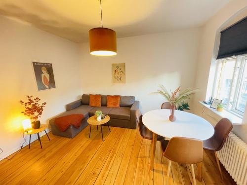 uma sala de estar com um sofá e uma mesa em aday - Sunset Suite em Randers