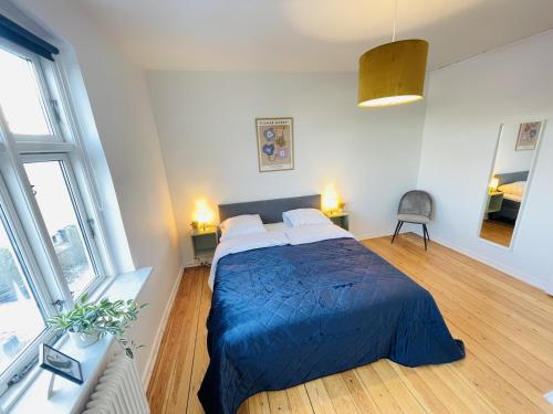 a bedroom with a bed with a blue comforter at aday - Sunset Suite in Randers
