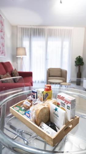 a tray of food on a glass table in a living room at Apartamentos Real Lleida in Lleida