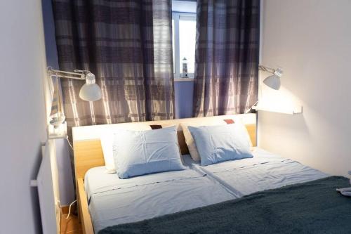a bedroom with a bed with two pillows and a window at Charming traditional house in tiny, cozy village in Vale de Boi