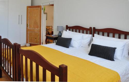 une chambre avec un grand lit avec deux oreillers dans l'établissement Aloe Cottage, à Montagu