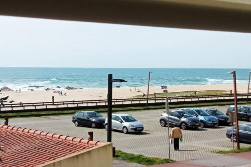 a group of cars parked in a parking lot near the beach at Apartamento Fragosa - Vieira's Mar in Póvoa de Varzim