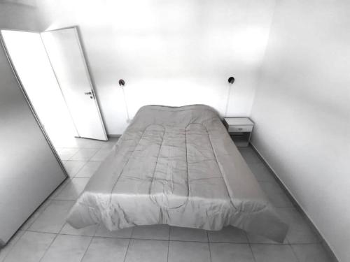 1 cama grande en una habitación blanca con 2 espejos en Dúplex con patio y parrilla en Terrazas del Sol en Neuquén