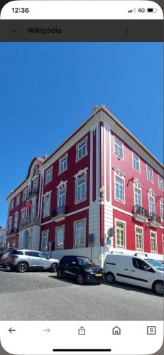 a red building with cars parked in front of it at Apartamento Fazunchar in Figueiró dos Vinhos