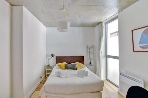 sypialnia z dużym białym łóżkiem i oknem w obiekcie Le Faubourg - Charmant duplex pour 4 avec parking w mieście Bordeaux