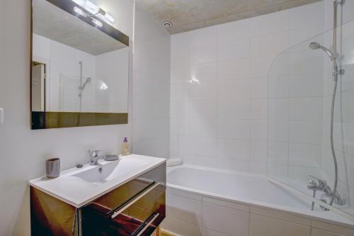 a white bathroom with a sink and a bath tub at Le Faubourg - Charmant duplex pour 4 avec parking in Bordeaux