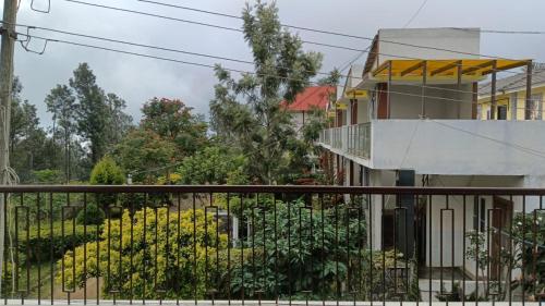 ein Haus mit einem Balkon und einem Zaun in der Unterkunft Sushmika Home in Yercaud