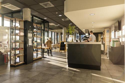 a store lobby with a counter and people in it at Campanile Le Mans Centre - Gare in Le Mans