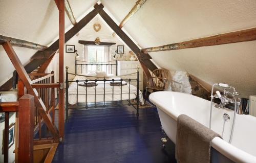 a attic bathroom with a bath tub and a bedroom at Y Cartws near Llangrannog in Llangrannog