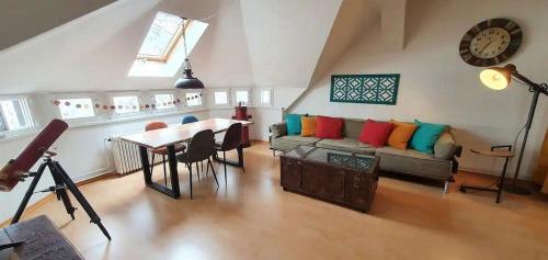 a living room with a couch and a table and a clock at Ferienwohnungen Leipzig Musikviertel Zentrum Süd - zentral und dennoch ruhig in Leipzig