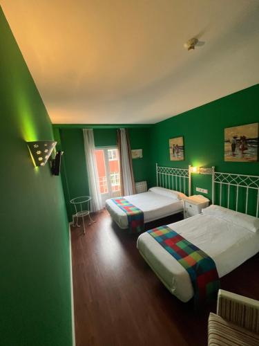 ein grünes Zimmer mit 2 Betten und einer grünen Wand in der Unterkunft Orquídea Real in Villablino