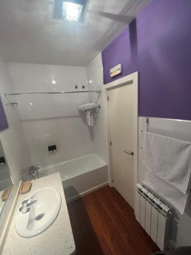 W łazience znajduje się umywalka i wanna. w obiekcie Orquídea Real w mieście Villablino