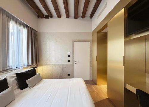 a bedroom with a white bed and a television at Palazzo Pianca in Venice