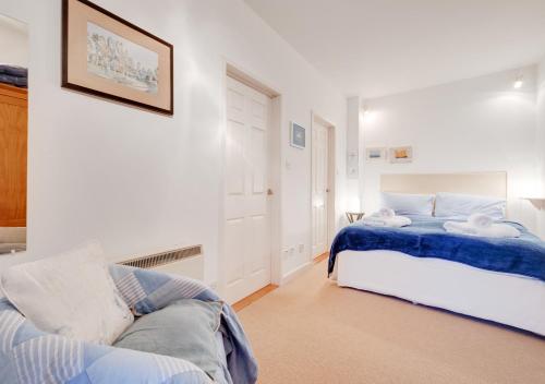 a white bedroom with a bed and a couch at Low Tide in Aldeburgh