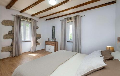 1 Schlafzimmer mit einem weißen Bett und 2 Fenstern in der Unterkunft Casa Baroni in Rabac