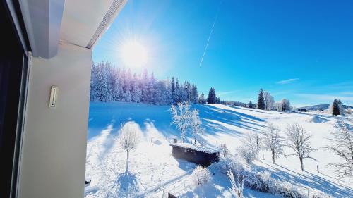 a view of a snow covered field with a lake at MV Vacances in Les Rousses