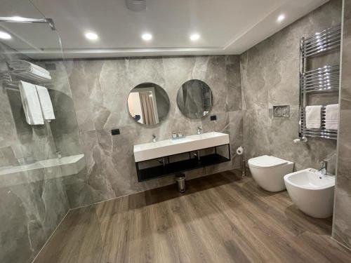 a bathroom with a sink and a toilet and a mirror at Hotel Zara Milano in Milan