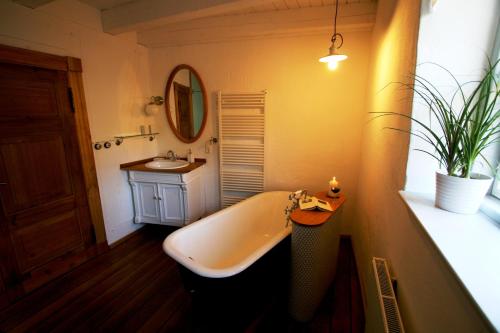 ein Badezimmer mit einer Badewanne und einem Waschbecken in der Unterkunft Dorphus in Neuenkirchen auf Rügen