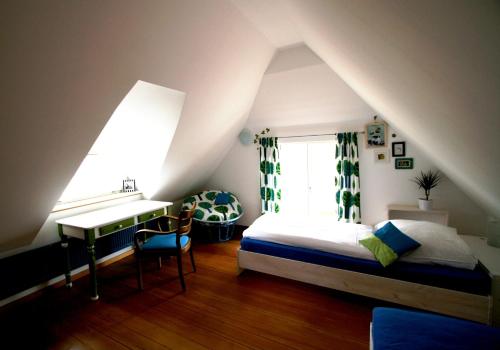 a bedroom with a bed and a desk in a attic at Dorphus in Neuenkirchen auf Rugen