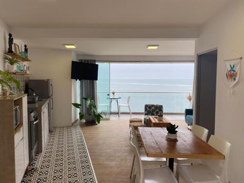 Sala de estar con mesa de comedor y vistas al océano en FRENTE AL MAR, en San Bartolo