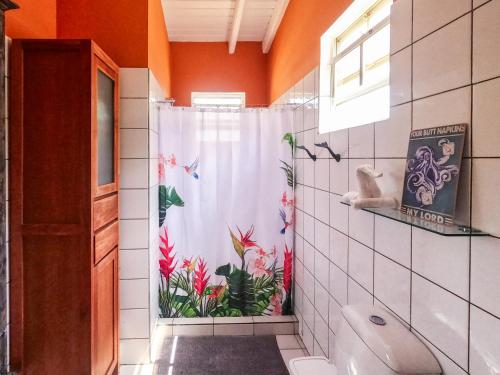a bathroom with a shower curtain with flowers on it at Treasure By The Sea Bonaire in Kralendijk