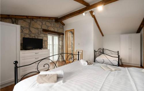 a bedroom with a large bed and a television at Casa Zamarija in Labin