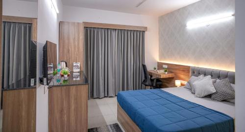a bedroom with a bed and a desk and a television at Yello! ITPL in Bangalore