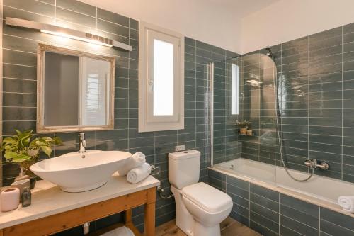 een badkamer met een wastafel, een toilet en een bad bij AELIA VILLA in Fiskardho