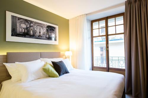 Postel nebo postele na pokoji v ubytování Hôtel des Voyageurs Boutique