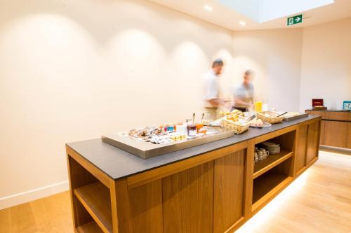 two people are preparing food in a kitchen at Hôtel des Voyageurs Boutique in Lausanne