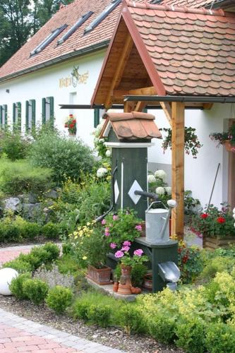 a garden with a bird feeder in front of a house at Kürbishof Gartner in Fehring
