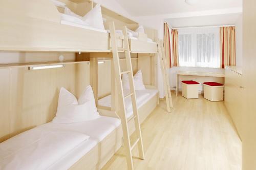 Zimmer mit 2 Etagenbetten und einer Leiter in der Unterkunft Jugendgästehaus Mondsee in Mondsee