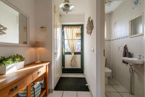 uma casa de banho com um lavatório e um WC em Buitenplaats 27 Callantsoog em Callantsoog