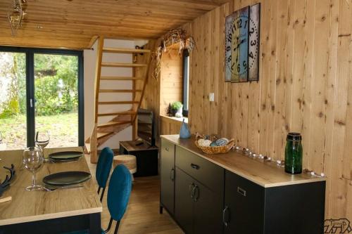 una cocina con mesa y sillas en una cabaña en Gite de la Ravanne/Le petit nid en Ramonchamp