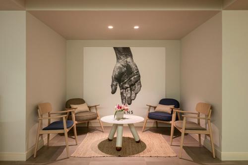 a waiting room with a table and chairs at ME Sitges Terramar in Sitges