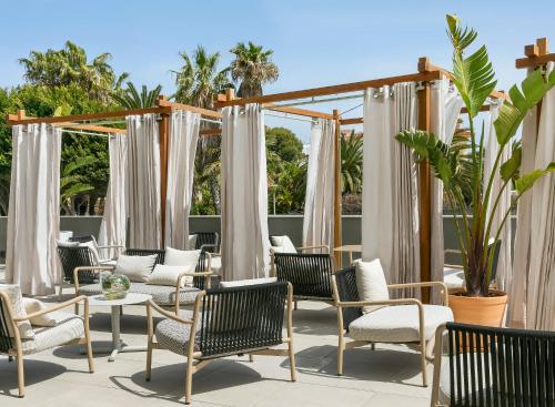 a group of chairs and tables on a patio at ME Sitges Terramar in Sitges